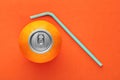 Orange fruit with pop up silver top of a can and a straw on orange background Royalty Free Stock Photo