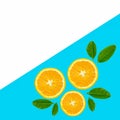 Orange fruit slices with leaves on blue background Royalty Free Stock Photo