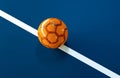 Orange futsal ball on blue indoor soccer field Royalty Free Stock Photo