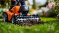 Orange garden tiller working in a grassy yard Royalty Free Stock Photo