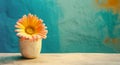 Orange gerbera flower in old clay pot on blue textured stucco wall. Floristic decoration. Natural floral background. Created with Royalty Free Stock Photo