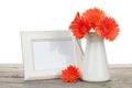 Orange gerbera flowers and photo frame on wooden table Royalty Free Stock Photo