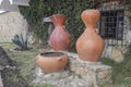 Orange giant ceramic flower pots into a town garden with climber plants