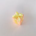 An orange gift box on an off-white background, square. Royalty Free Stock Photo