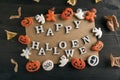 Orange gingerbread cookies and incription Happy halloween on black wooden table. Postcard Happy Halloween sweet background