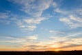 Orange glow of a sunset with a blue sky and white clouds over a Royalty Free Stock Photo