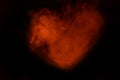 Orange glowing heart from cigarette vapor on a dark background