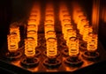 Orange-glowing metal coils are arranged neatly in rows on a rectangular metallic platform. Each Royalty Free Stock Photo