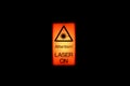 Orange glowing warning sign alerting to industrial laser room being active Royalty Free Stock Photo