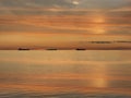 orange  gold sunset cloudy  at sea water reflection ship on horizon nature landscape seascape Royalty Free Stock Photo