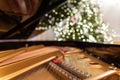 The grand piano interior with visible strings In the background a blurred Christmas tree, ornaments and lights Royalty Free Stock Photo