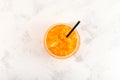 Orange Granizado in glass on light textured surface, top view. Refreshing Slushie drink. Sweet Citrus Shaved ice. Street food and Royalty Free Stock Photo