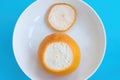 Orange grapefruit with cut off the top end on white plate on blue background. Top view, diet concept Royalty Free Stock Photo