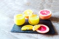 Orange grapefruit summer coctails juice in glasses, fresh fruits on cutting desk, wooden background with copy space Royalty Free Stock Photo