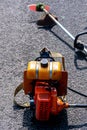 Orange grass cutter or trimmer machine under the sunlight
