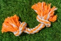 Orange gray rag dog toy on synthetic grass hard light