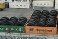 Orange and green containers loaded with big tires for heavy goods lorry or trucks.