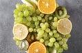 Orange , green grapes, kiwi, Apple and lemon slices on a gray, fresh citrus and fruit Royalty Free Stock Photo