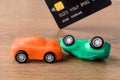 Orange and green toy car crush accident and credit card. Concept of car buying, renting, service, repair and insurance costs. Royalty Free Stock Photo