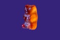 Orange gummy bear macro on dark blue background floating Royalty Free Stock Photo