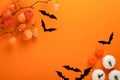 Orange Halloween background. Flock of black bats and branch of dry orange flowersfor Halloween. Black paper bat silhouettes on Royalty Free Stock Photo