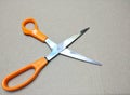 Orange handle stainless steel scissors placed on a brown background Royalty Free Stock Photo