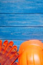 Orange hard hat and gloves on wooden vintage blue boards Royalty Free Stock Photo
