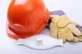 Orange hard hat, goggles, protective mask, respirator and safety gloves on a white background. Royalty Free Stock Photo