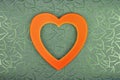 Orange heart on green floral  textured  background Royalty Free Stock Photo