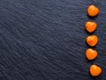 Orange heart shaped pills or candy on grunge black Royalty Free Stock Photo