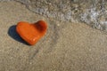 Orange heart shaped stone at the beach Royalty Free Stock Photo