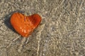 Orange heart shaped stone at the beach Royalty Free Stock Photo