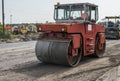 Orange Heavy Vibration roller compactor at asphalt pavement works for road repairing. Working on the new road Royalty Free Stock Photo