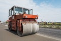 Orange Heavy Vibration roller compactor at asphalt pavement works for road repairing. Working on the new road Royalty Free Stock Photo