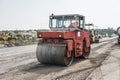 Orange Heavy Vibration roller compactor at asphalt pavement works for road repairing. Working on the new road Royalty Free Stock Photo