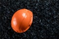 An orange helmet of a miner lies on a heap of coal, open pit coal mining, copy space. Fossil fuels, environmental pollution Royalty Free Stock Photo