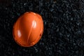 An orange helmet of a miner lies on a heap of coal, open pit coal mining, copy space. Fossil fuels, environmental pollution Royalty Free Stock Photo