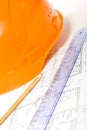 Orange helmet, pencil, ruler and blueprint