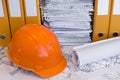 Orange helmet and project drawings Royalty Free Stock Photo