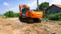 The orange Hitachi excavator is parked in construction access