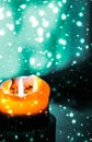 Orange holiday candle on green sparkling snowing background, luxury branding design for Halloween, New Years Eve and Christmas Royalty Free Stock Photo