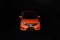 Orange Honda jazz car on dark background. Royalty Free Stock Photo