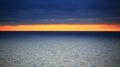 Orange horizon between dark clouds and Baltic sea