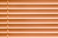 Orange horizontal blinds on the window create a rhythm_ Royalty Free Stock Photo