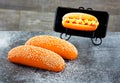 Orange hot dog bun with sesame seeds on a floured stone plate Royalty Free Stock Photo