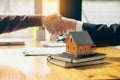 The orange house on tigerskin and the sales representative and the new homeowner join hands to sign a contract to buy the house or Royalty Free Stock Photo