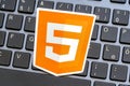 Orange HTML5 markup language logo sticker desktop PC computer keyboard, web development technology work concept, learning Royalty Free Stock Photo