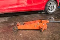 Orange Hydraulic car jack and red car