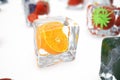 Orange in ice cube isolated on white with depth of field effects. Ice cubes with fresh berries. Berries fruits frozen in Royalty Free Stock Photo