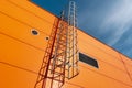 Orange industrial building wall with metal ladder